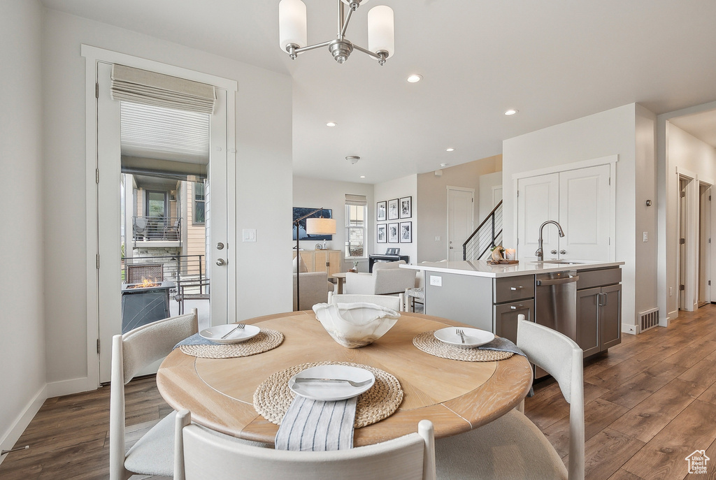 Dining space with wood finished floors, a chandelier, baseboards, and recessed lighting