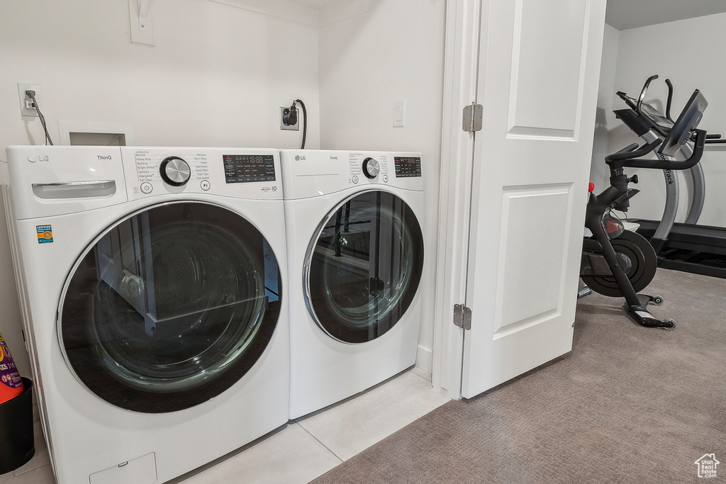 Washroom with separate washer and dryer and carpet flooring