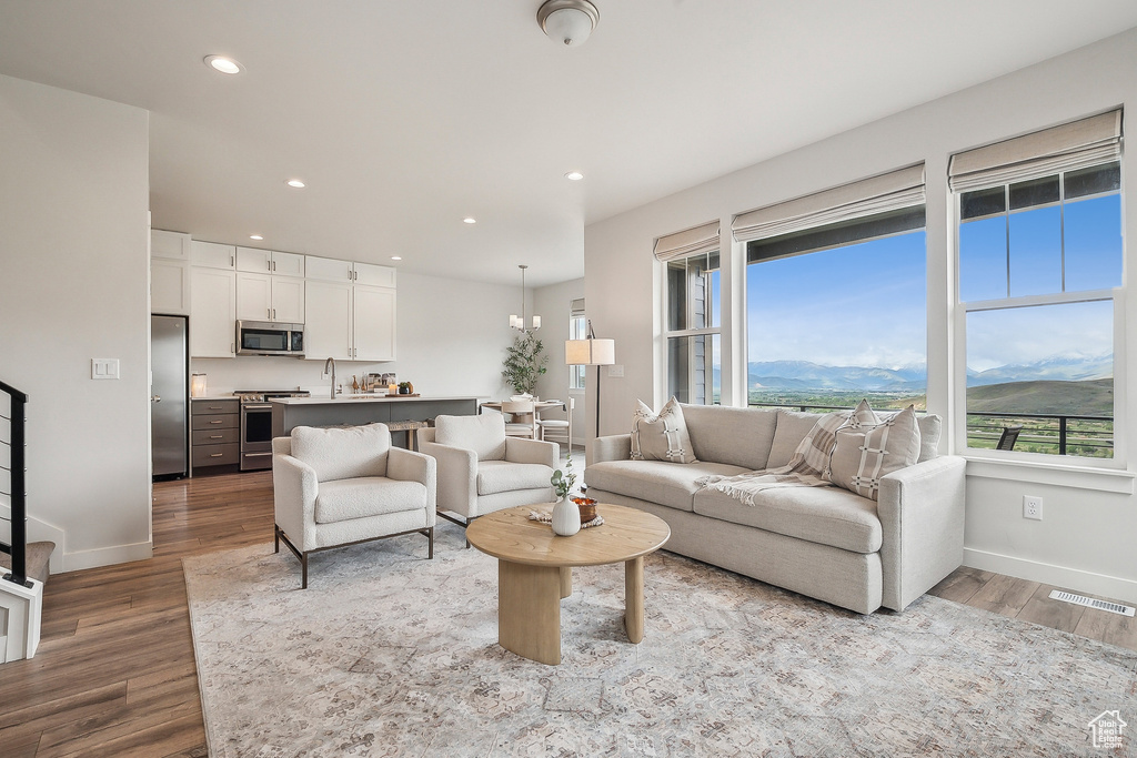 Living area with baseboards, wood finished floors, recessed lighting, and a mountain view