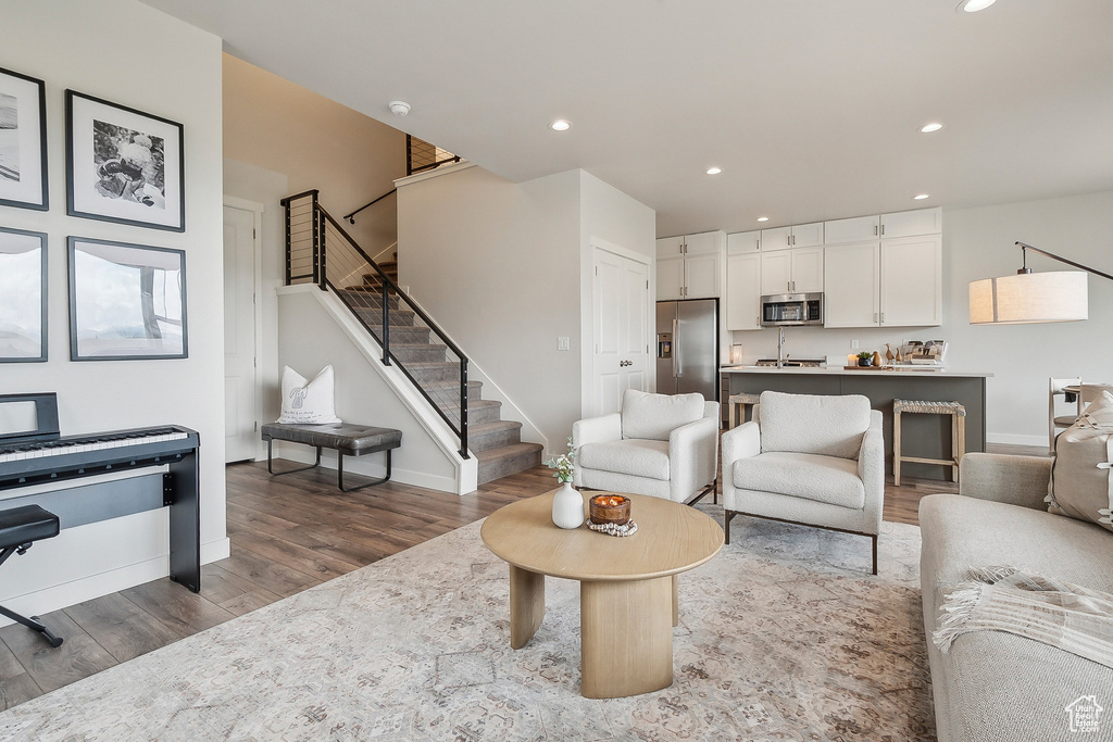 Living area featuring wood finished floors, stairway, recessed lighting, and baseboards