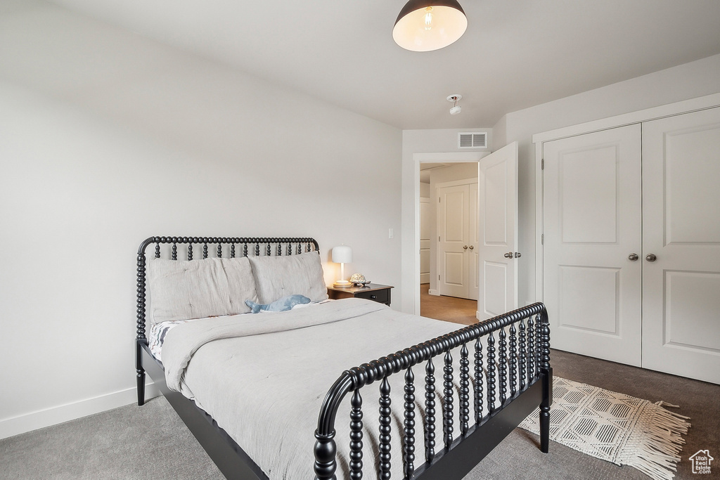 Carpeted bedroom featuring baseboards and a closet