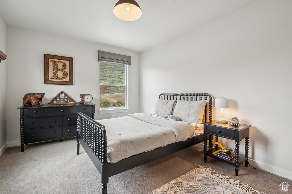Bedroom featuring light carpet and baseboards