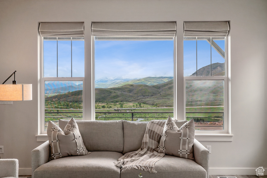 Living room with a mountain view, baseboards, and plenty of natural light