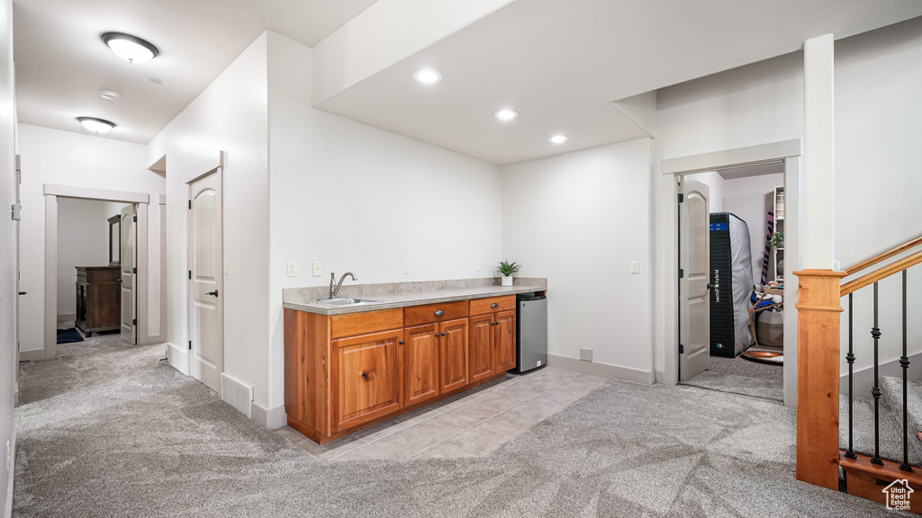 Bar featuring light colored carpet, a sink, baseboards, recessed lighting, and stairs