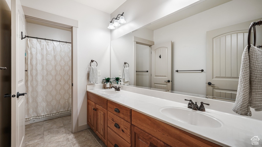 Bathroom with double vanity and tile patterned flooring