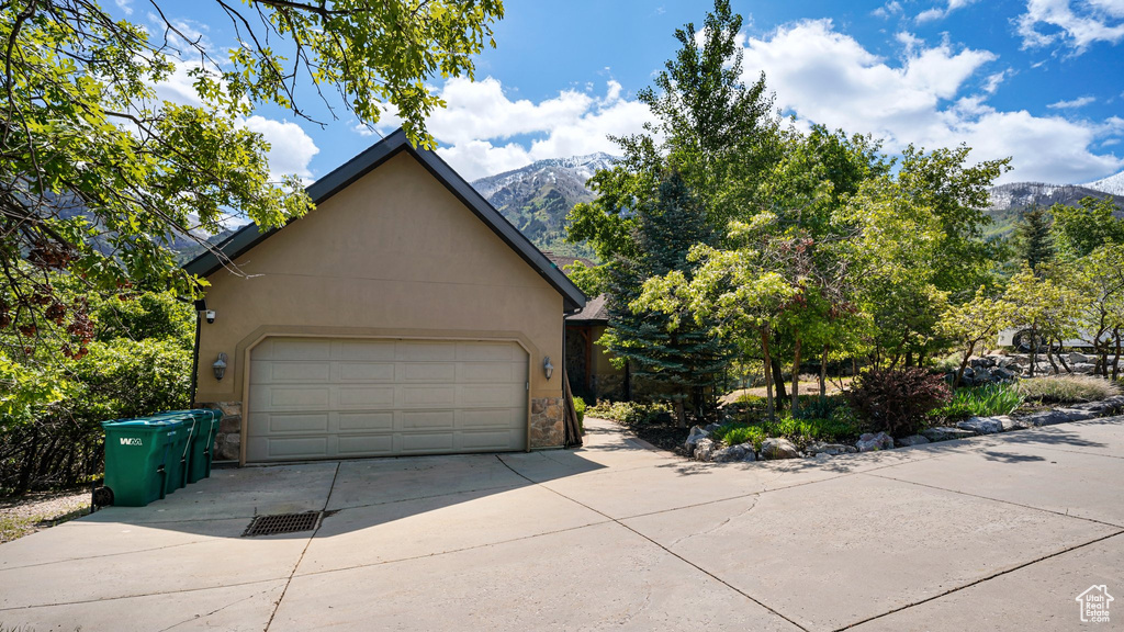 Garage with a mountain view and concrete driveway