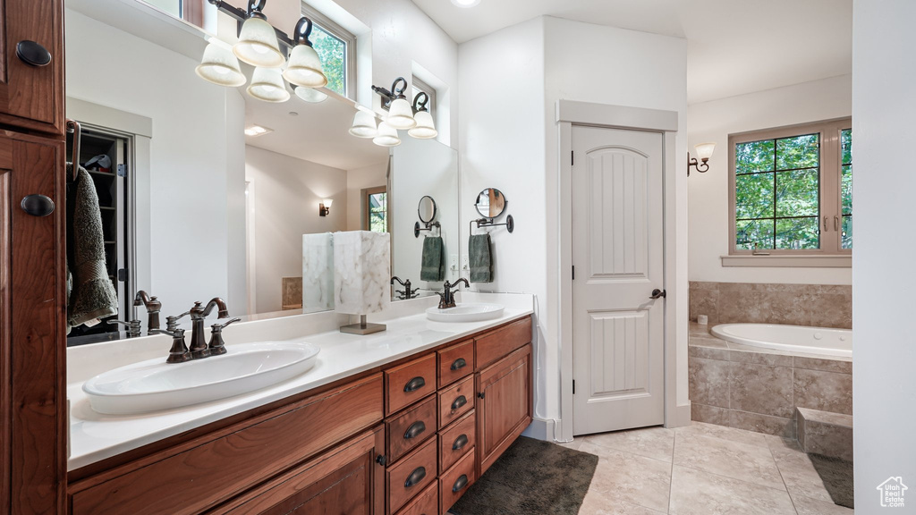 Bathroom with double vanity, tile patterned floors, a bath, and a closet