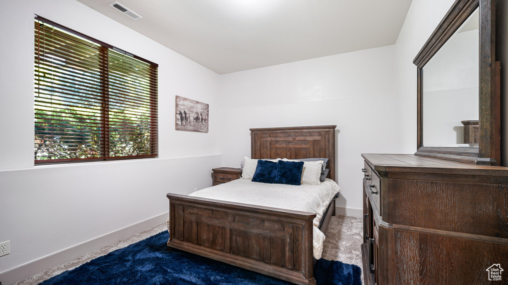 Bedroom featuring dark colored carpet and baseboards