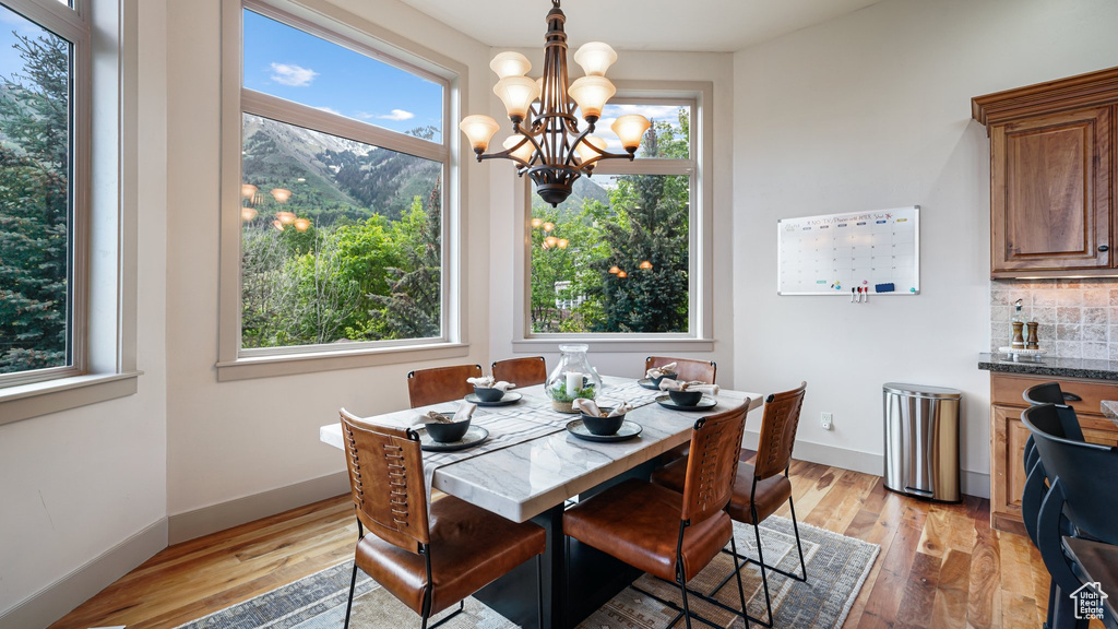 Dining space featuring a chandelier, light wood-style flooring, and baseboards
