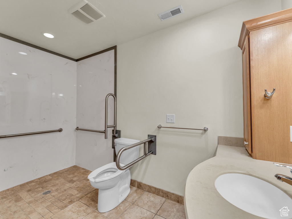 Bathroom with a sink, toilet, and tile patterned floors