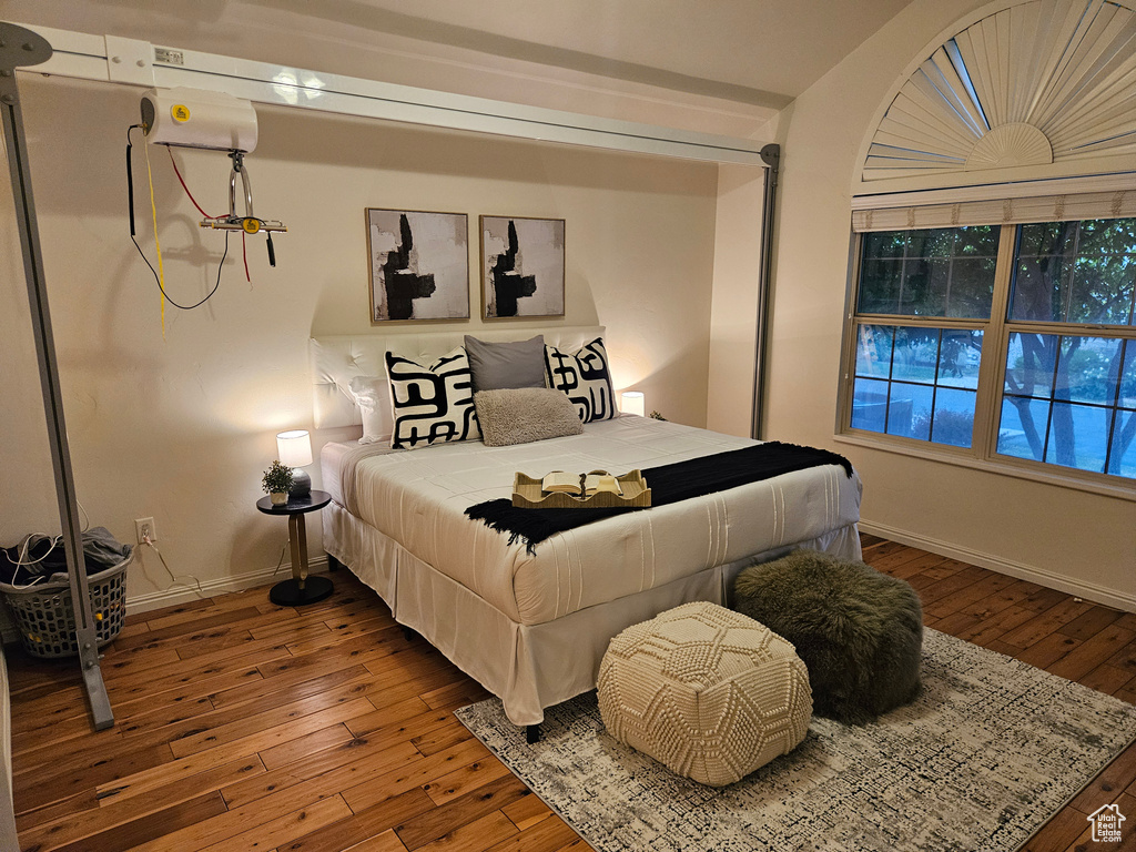 Bedroom featuring hardwood / wood-style flooring and baseboards