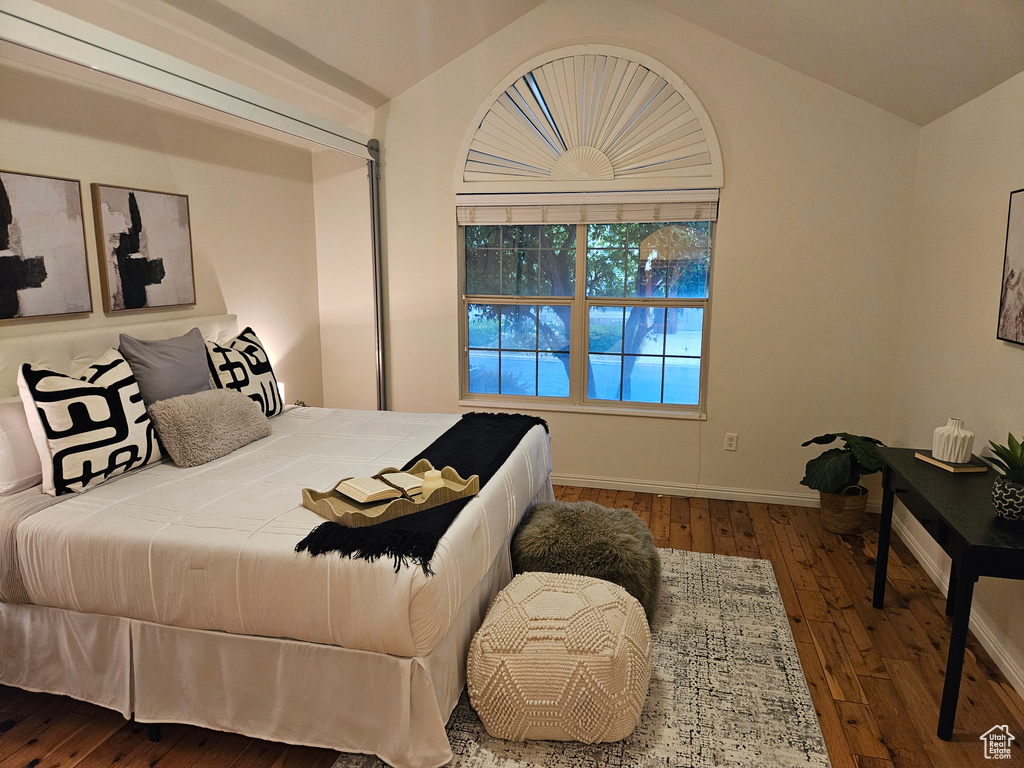 Bedroom with lofted ceiling and hardwood / wood-style floors