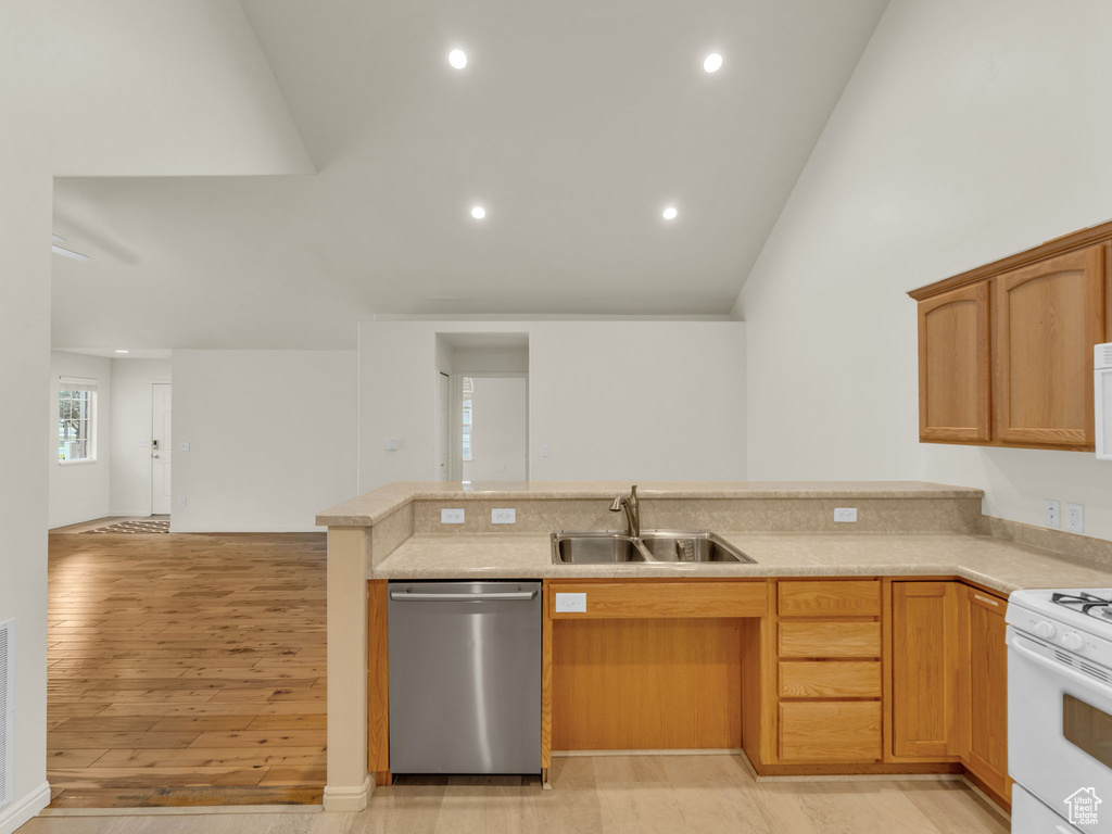Kitchen with stainless steel dishwasher, a sink, light countertops, white range with gas cooktop, and recessed lighting