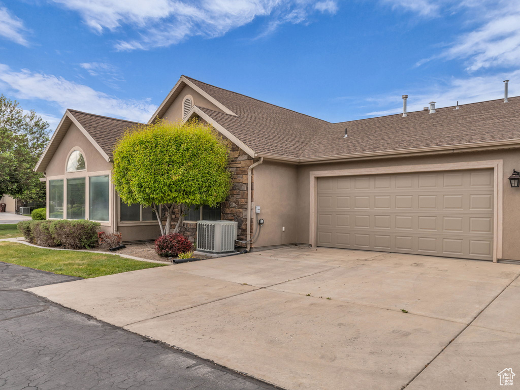 Single story home with stucco siding, concrete driveway, stone siding, and a garage
