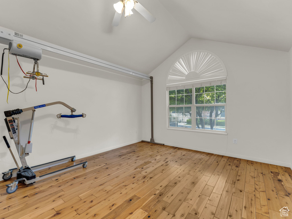 Workout area with hardwood / wood-style flooring, lofted ceiling, ceiling fan, and baseboards