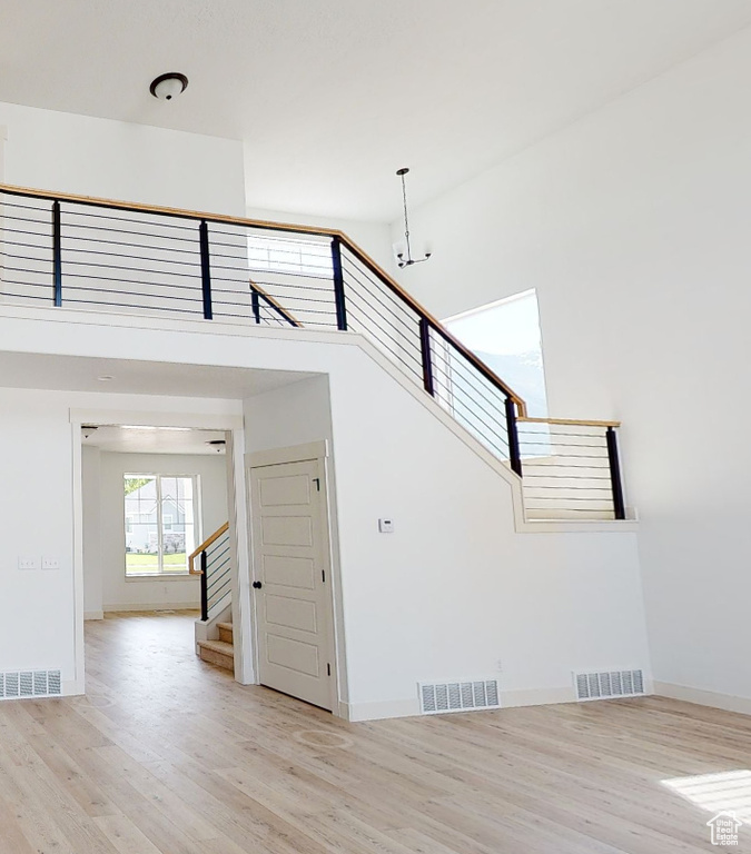 Stairs featuring wood finished floors, baseboards, and a chandelier