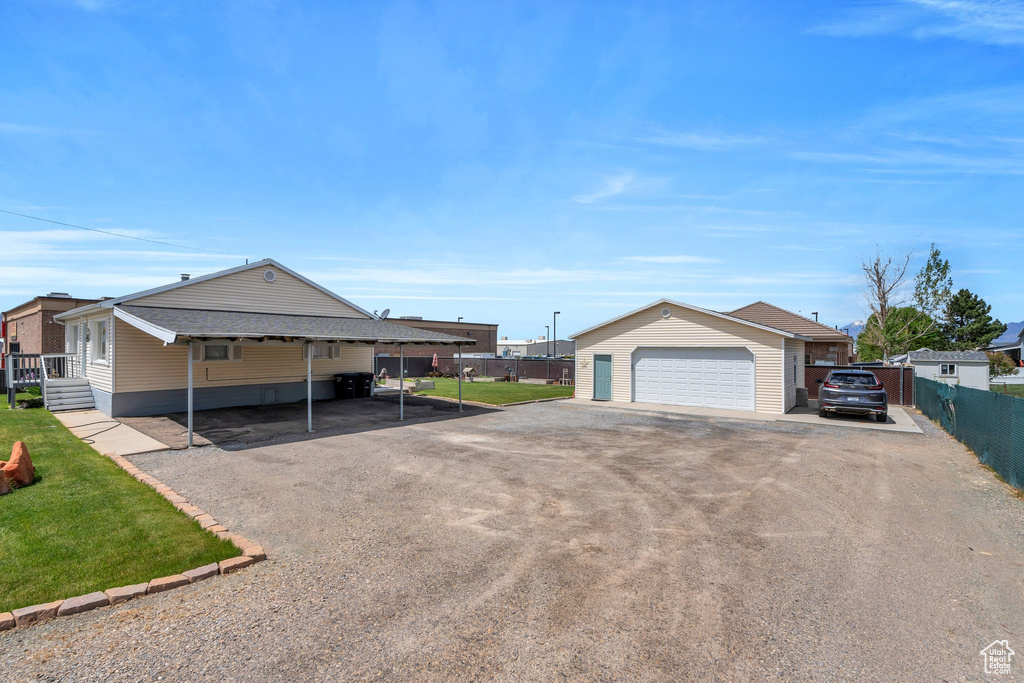 View of front of house with an outdoor structure, a garage, and driveway