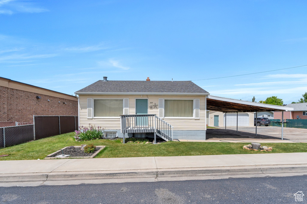 View of front facade with an attached carport, central AC unit, and driveway