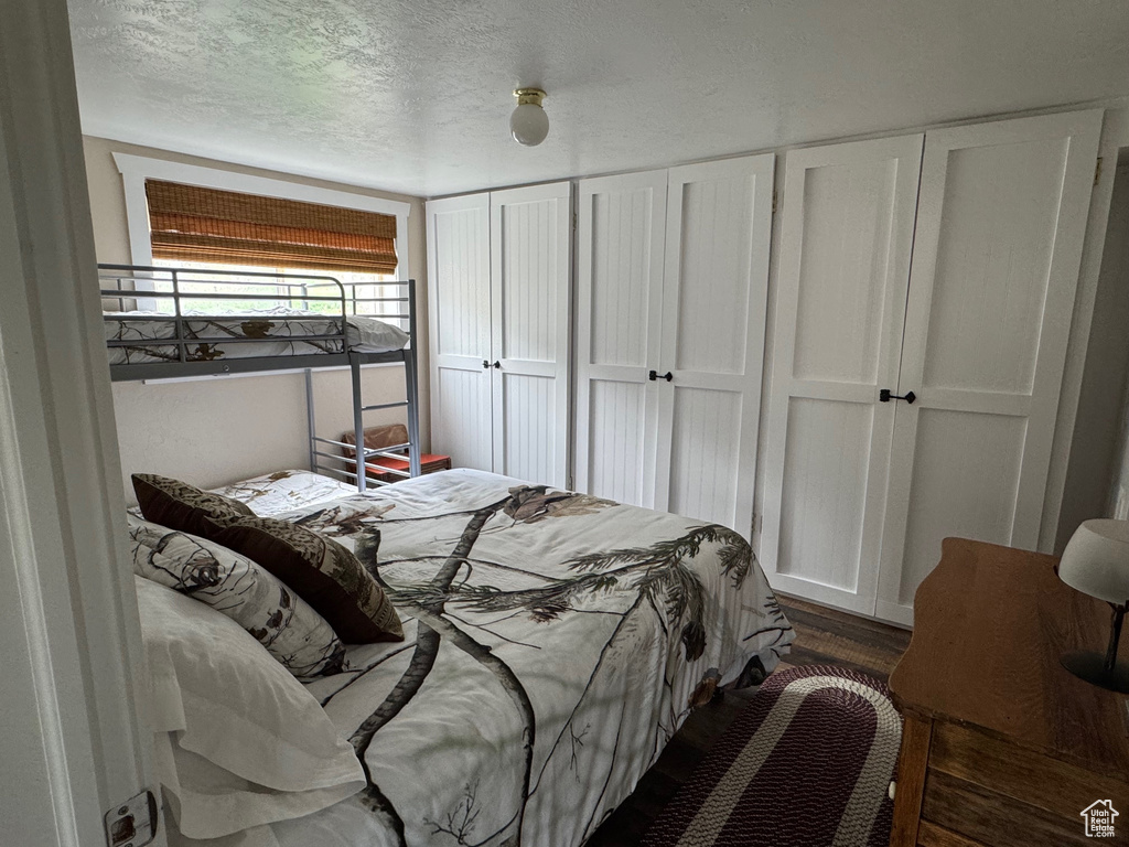 Bedroom featuring dark wood-style floors and a textured ceiling