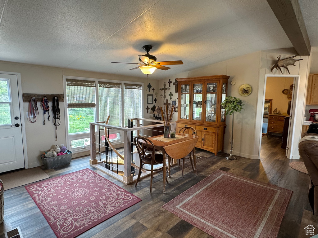Dining space with dark wood finished floors, ceiling fan, a textured ceiling, and lofted ceiling