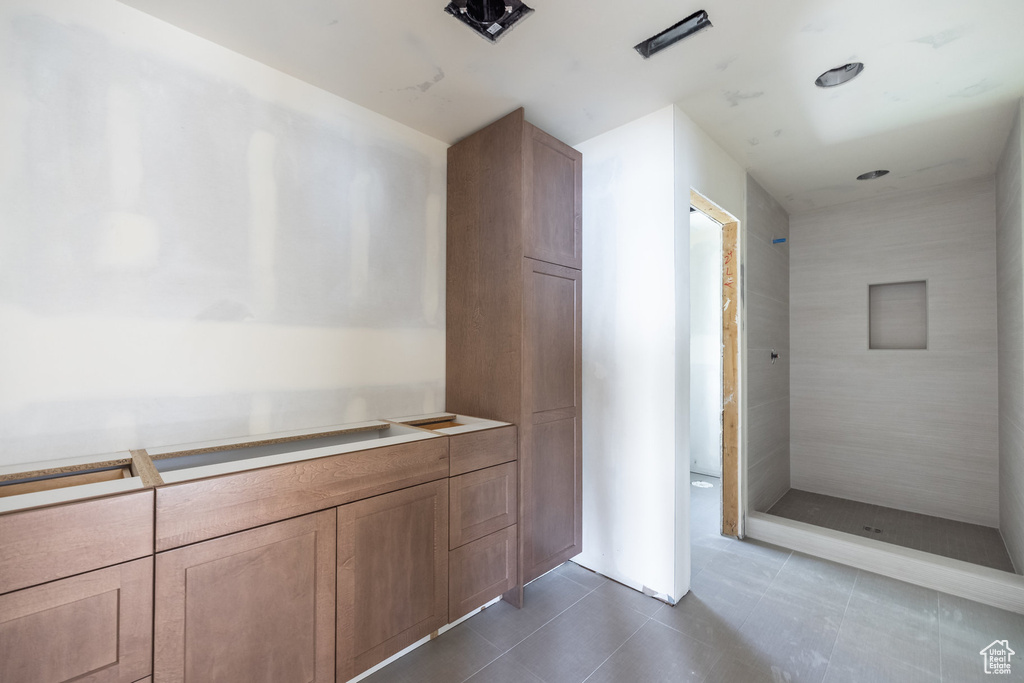 Full bath featuring tile patterned flooring and a tile shower