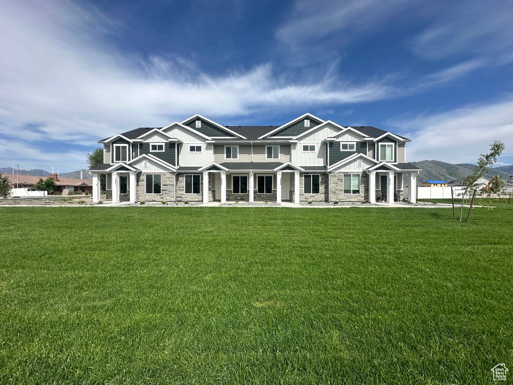 View of front of home with stone siding, board and batten siding, a mountain view, and covered porch