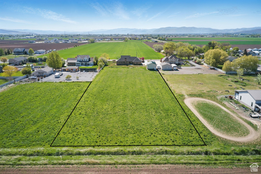 Aerial view of sparsely populated area with property parcel outlined and mountains