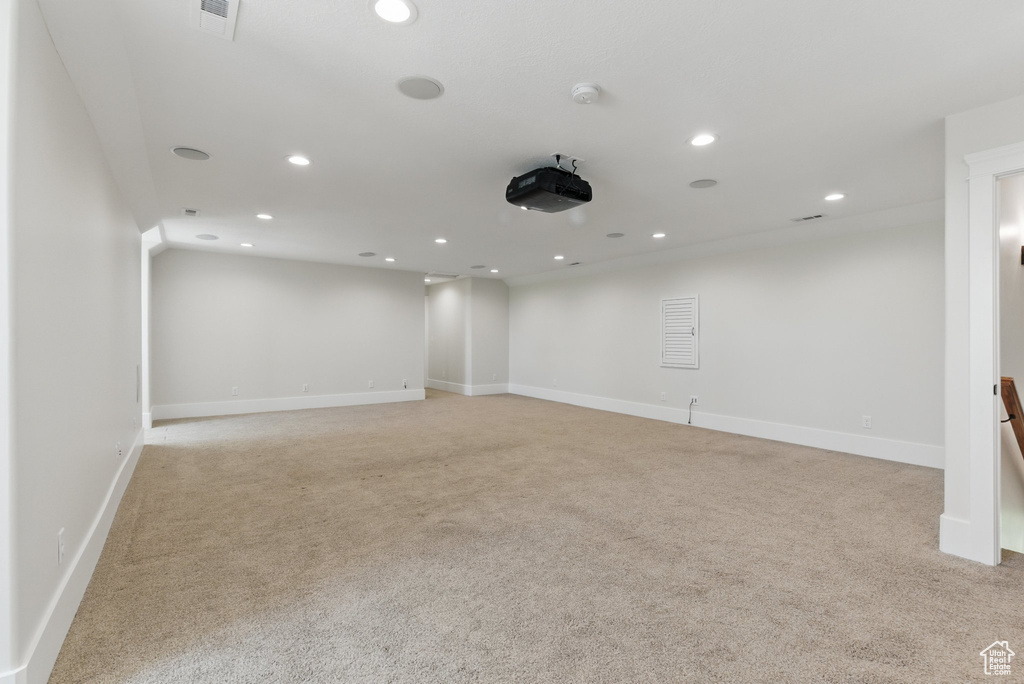 Empty room featuring light colored carpet, visible vents, baseboards, and recessed lighting