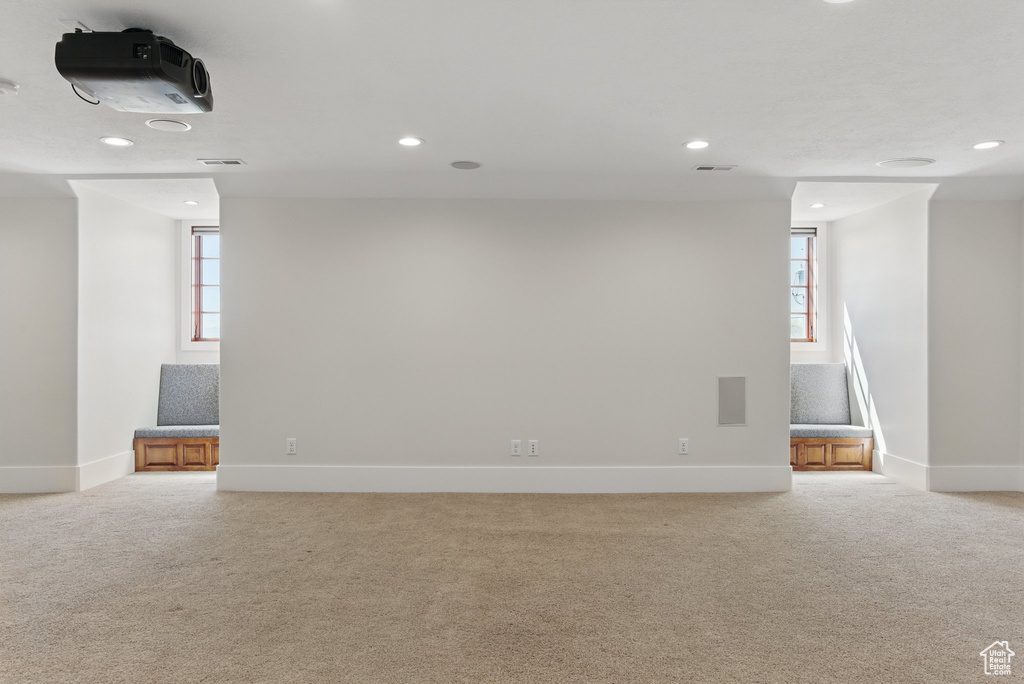 Basement featuring baseboards and light colored carpet