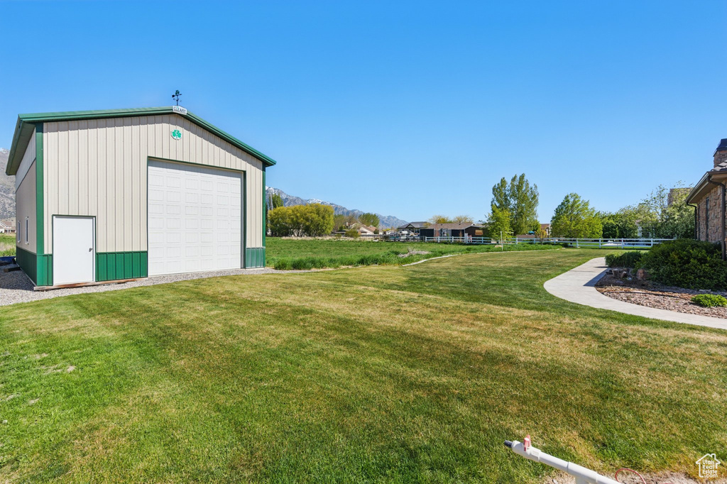 View of yard featuring a detached garage, a mountain view, and an outdoor structure