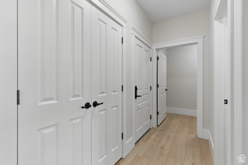 Corridor featuring light wood-style flooring and baseboards