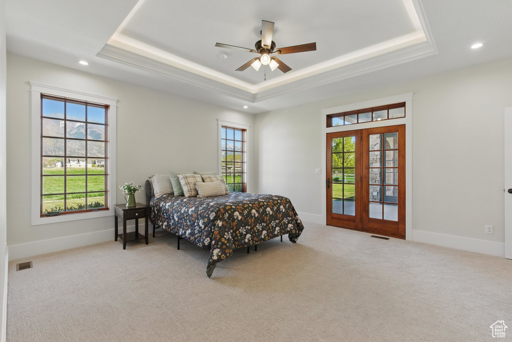 Carpeted bedroom with a tray ceiling, visible vents, and recessed lighting