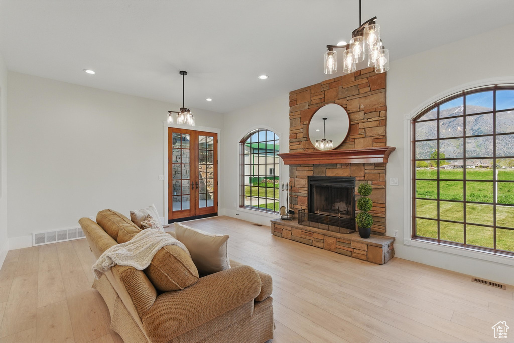 Living room featuring a healthy amount of sunlight, light wood finished floors, french doors, and visible vents