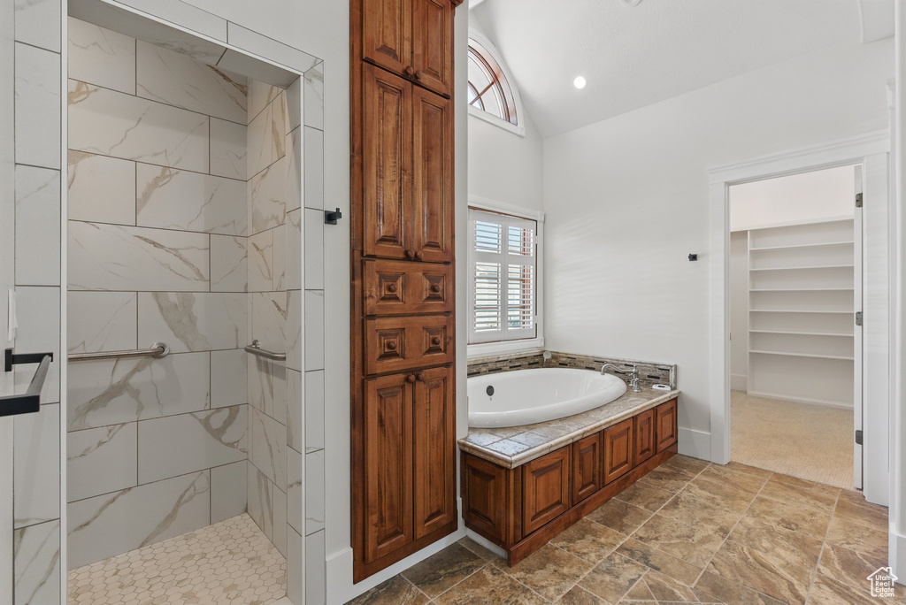 Full bathroom with a garden tub, vaulted ceiling, and a walk in shower