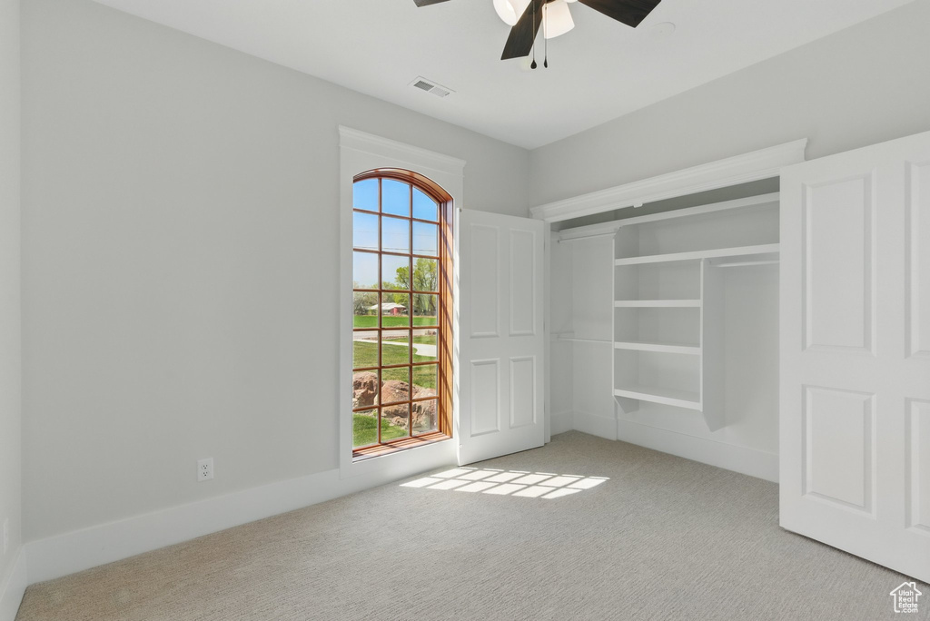 Unfurnished bedroom featuring ceiling fan, carpet, a closet, and visible vents