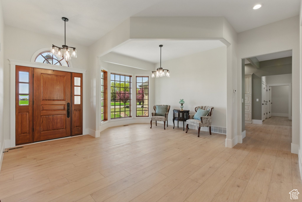 Entrance foyer featuring light wood-style floors, a chandelier, and baseboards