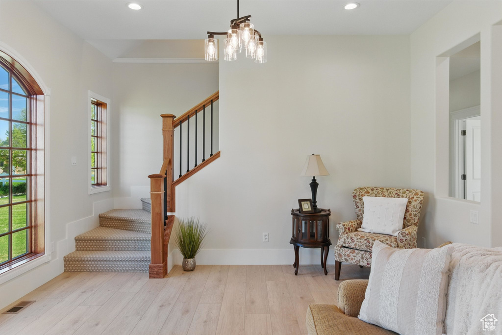 Living area featuring stairs, a notable chandelier, visible vents, light wood-style floors, and recessed lighting