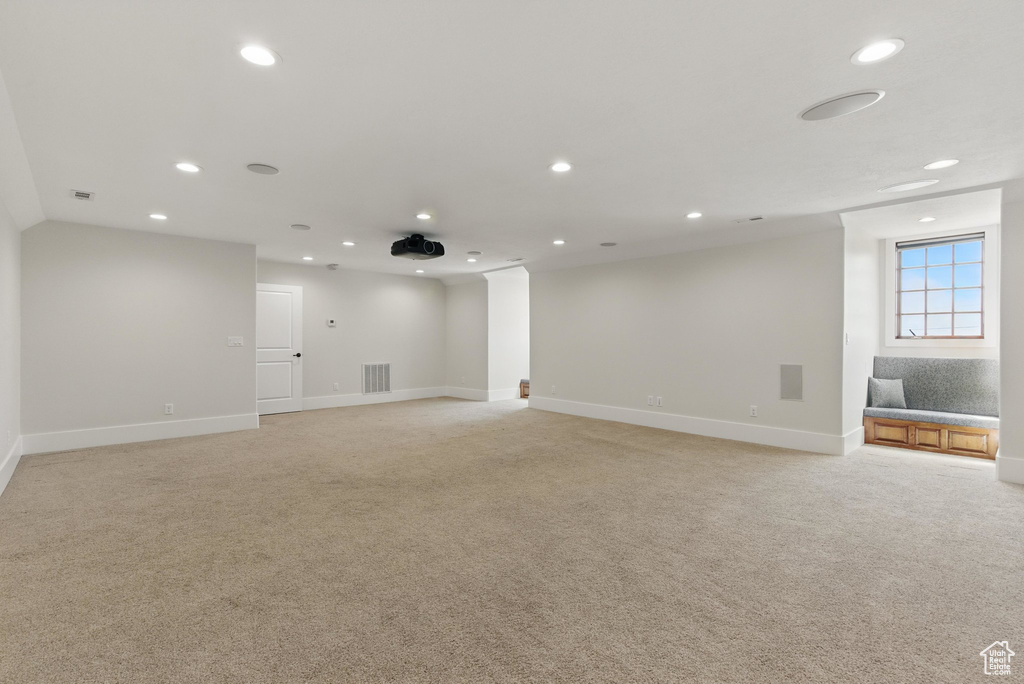 Spare room with light colored carpet, baseboards, and recessed lighting