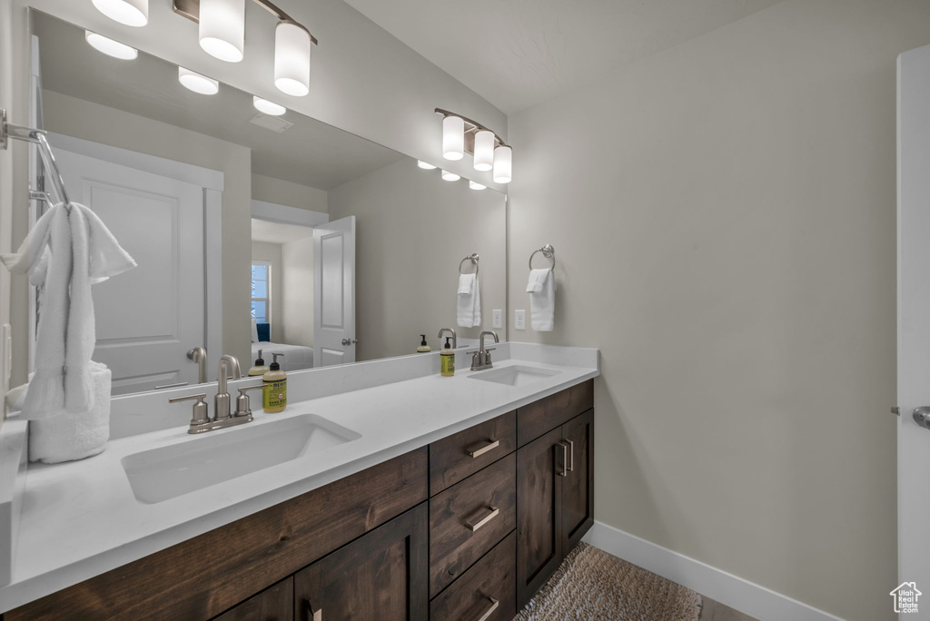 Bathroom with double vanity and baseboards