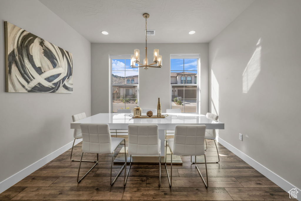 Dining room featuring a chandelier, dark wood finished floors, baseboards, and recessed lighting