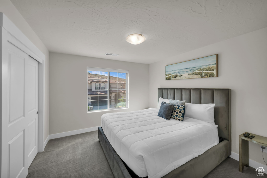 Bedroom featuring carpet flooring, baseboards, and a closet