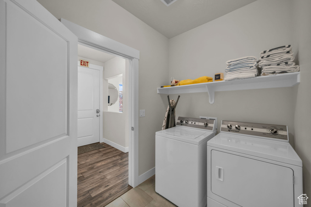 Laundry room featuring independent washer and dryer, baseboards, and light wood finished floors