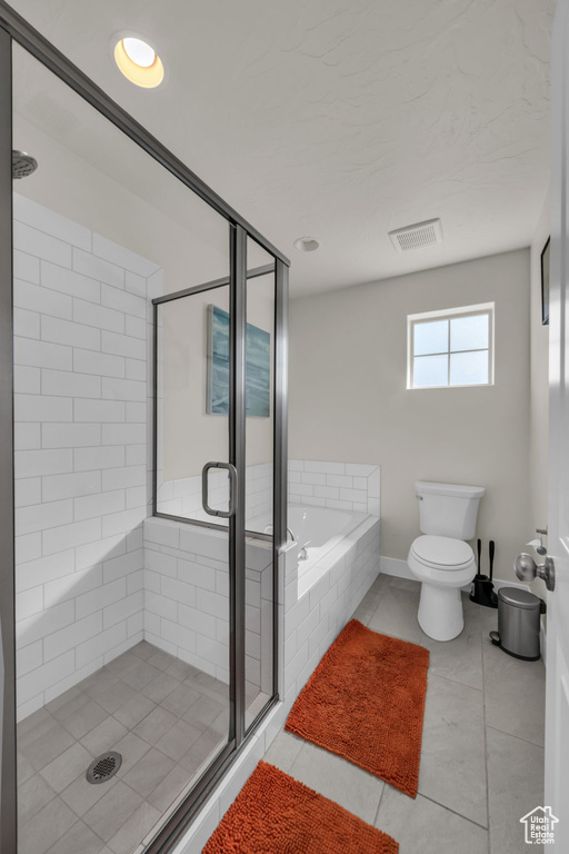 Bathroom with a stall shower, tile patterned floors, a bath, toilet, and baseboards