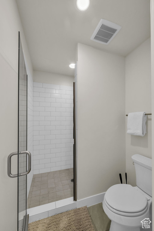 Full bathroom featuring toilet, a stall shower, and baseboards