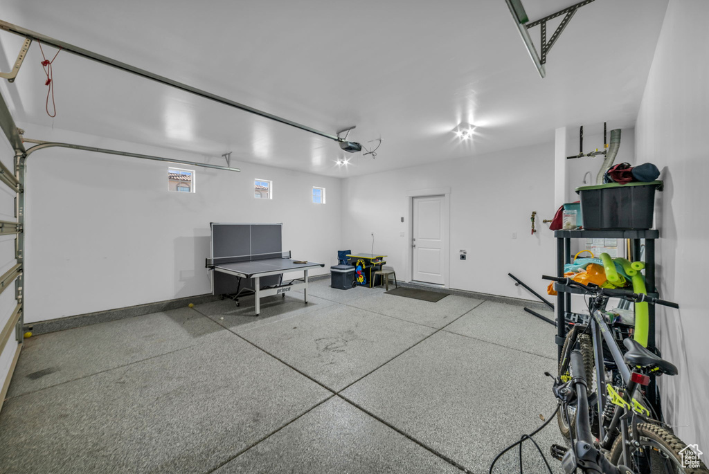 Garage featuring a garage door opener and baseboards