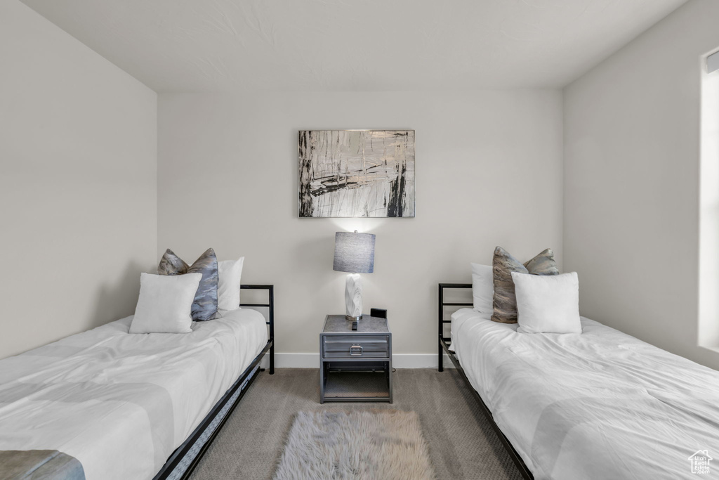 Bedroom featuring carpet and baseboards