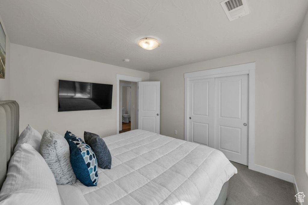 Bedroom with carpet, baseboards, and a closet
