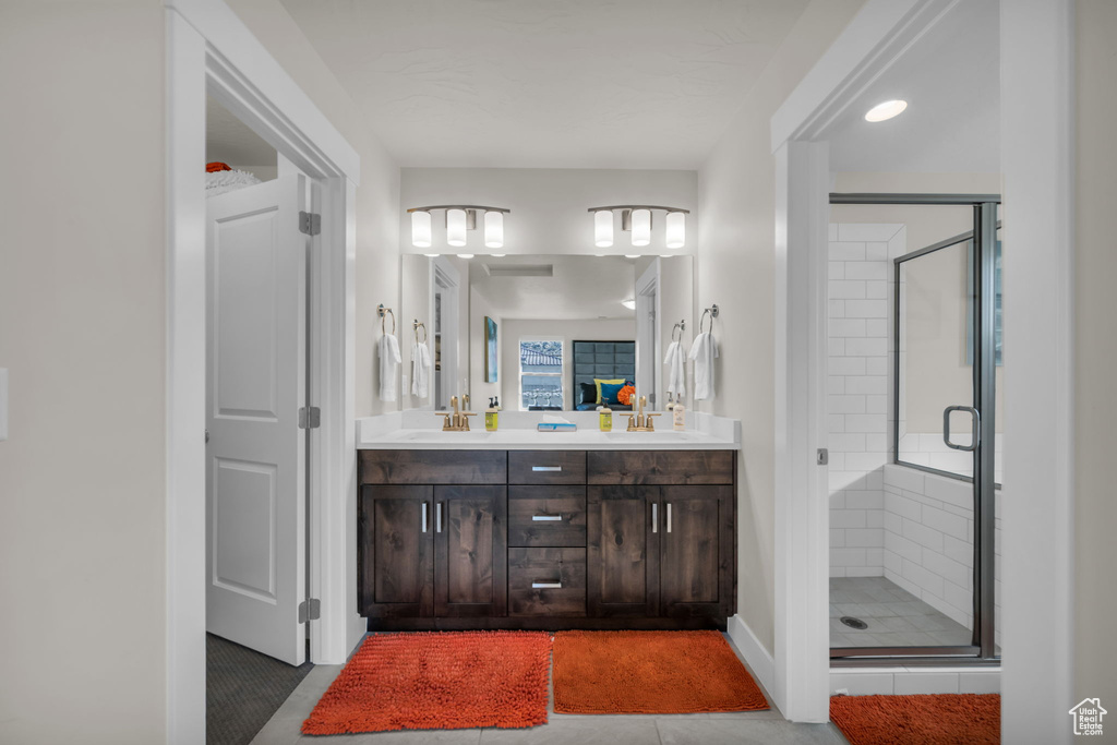 Bathroom featuring a stall shower and double vanity