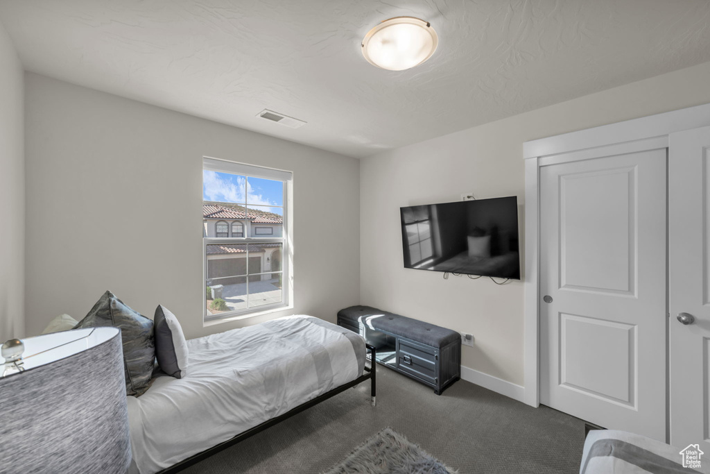 Bedroom with dark colored carpet and baseboards