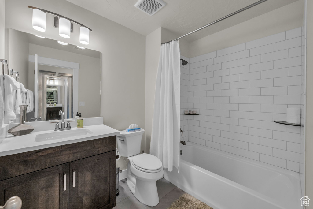 Full bath with toilet, vanity, shower / tub combo with curtain, and tile patterned flooring